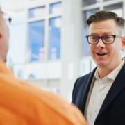Kaksi miestä keskustelee toimistossa