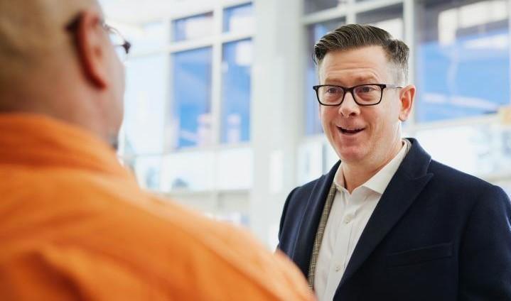 Kaksi miestä keskustelee toimistossa