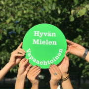 Monet kädet pitävät kylttiä: "Hyvän mielen vapaaehtoinen"