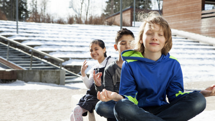 Alakoululaiset meditoivat koulun pihalla