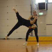 Aerobic-voimistelija nostaa toista lentokärrynpyörään.